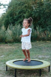 little girl on a rebounder trampoline